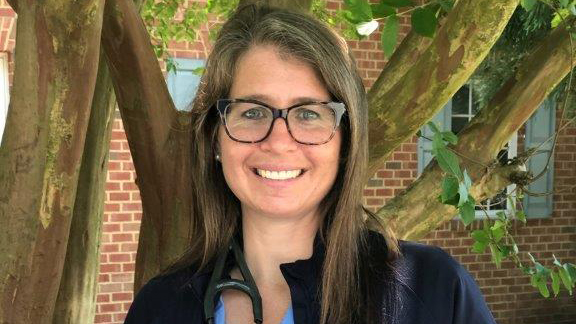 Emily Uyttewaal stands in front of a tree, smiling.