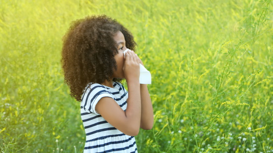 Young girl sneezing from allergies 