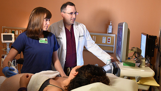chair of OB/GYN Dr. Pablo Argeles and technician give an ultrasound to an expecting mother