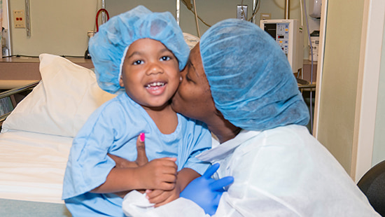 Mother kisses her son in hospital room