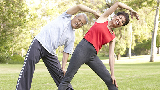 Happy couple stretching outside