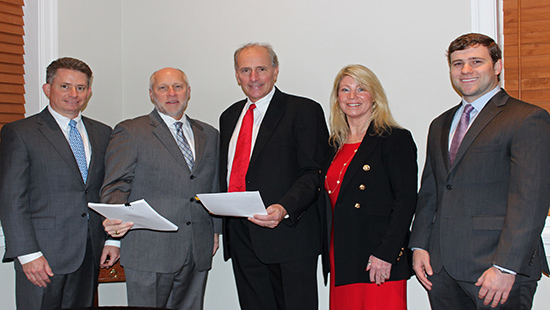 Ken Kozel and Charlie Fairchild holding settlement papers