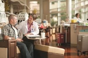 photo of a caregiver comforting a patient that's sitting in a chair at the treatment center
