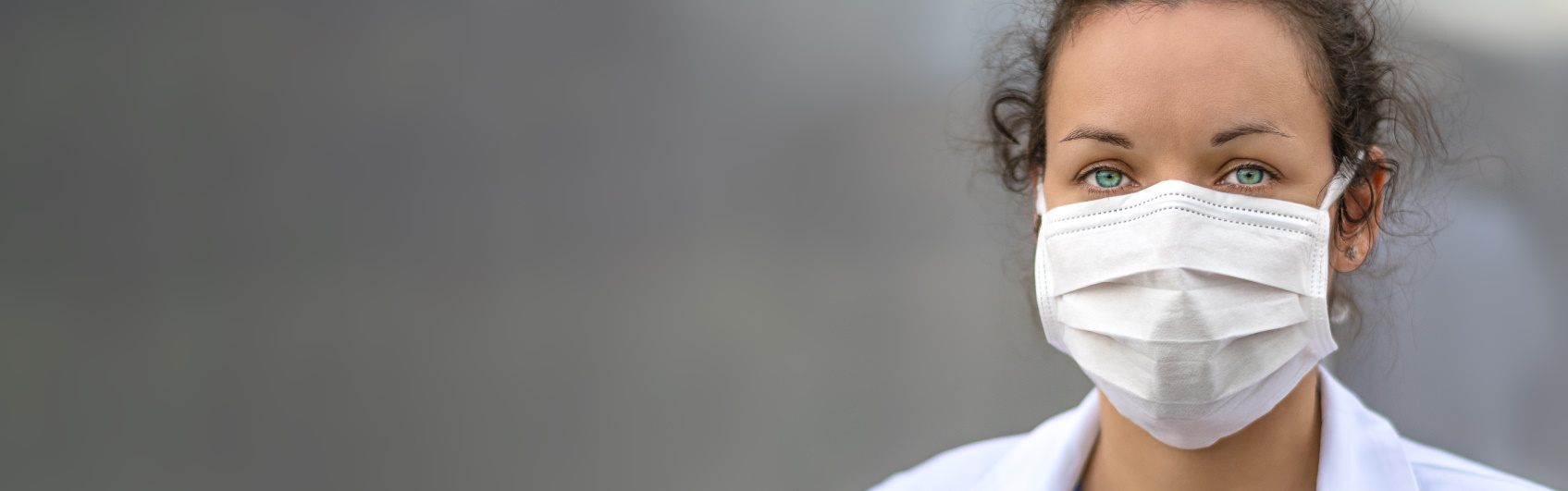 Woman in white coat wearing mask