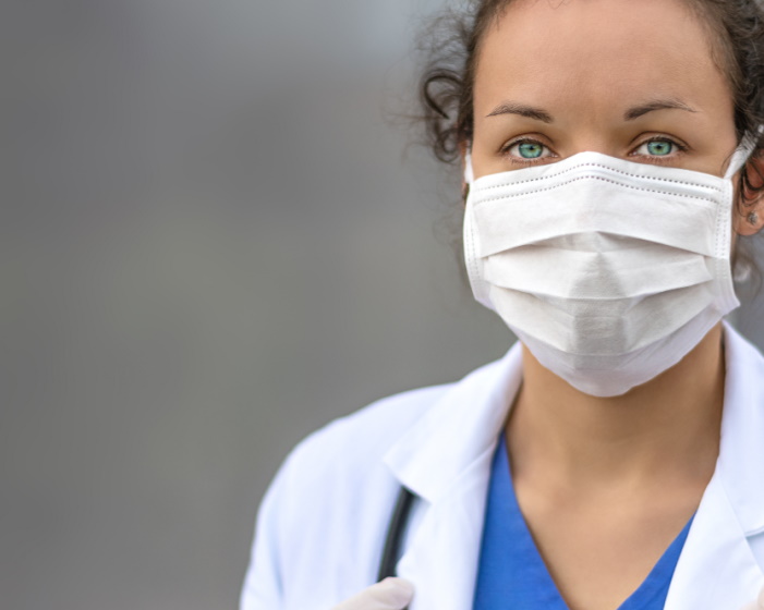 Woman in white coat wearing mask