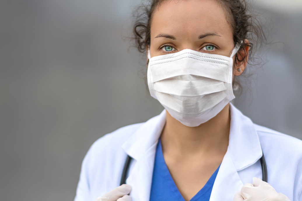 Woman in white coat wearing mask