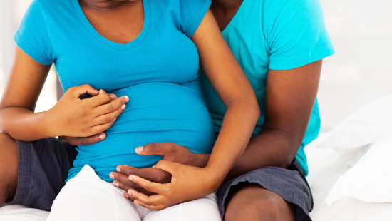 Close up of a man hugging a pregnant woman