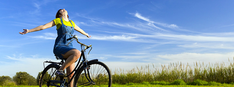 Person looking up at the sky while sitting on a bicycle