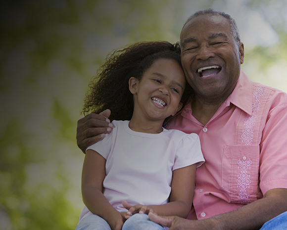A dad and his son laughing while playing football