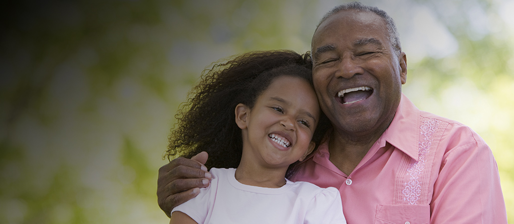 A dad and his son laughing while playing football