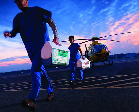 Transplant nurses transporting organs from a helicopter to the hospital