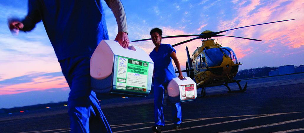 Transplant nurses transporting organs from a helicopter to the hospital