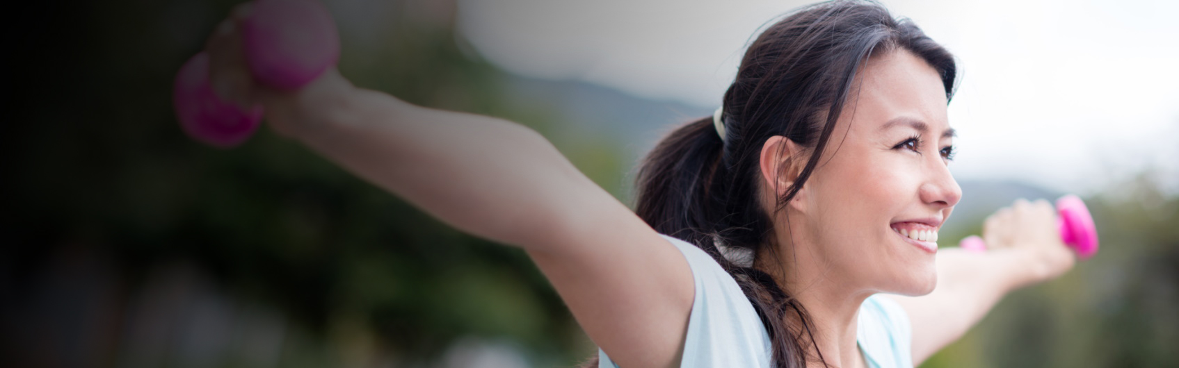 Smiling woman lifting hand weights