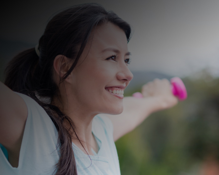 Smiling woman lifting hand weights