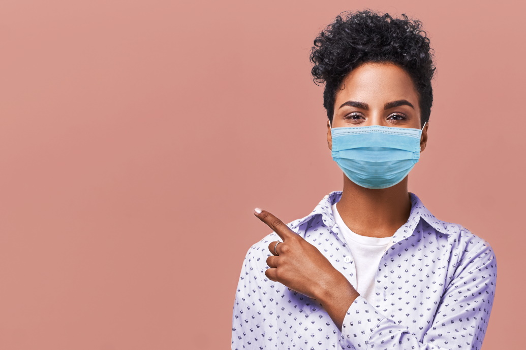 Young woman wearing a masks and pointing