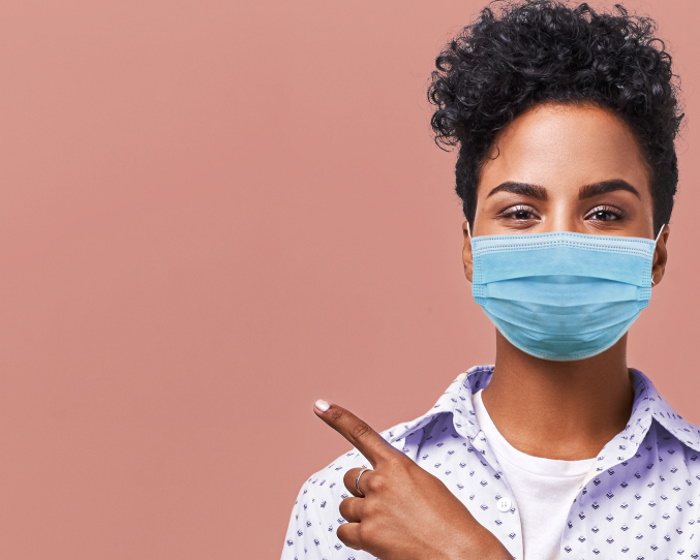 Young woman wearing a masks and pointing